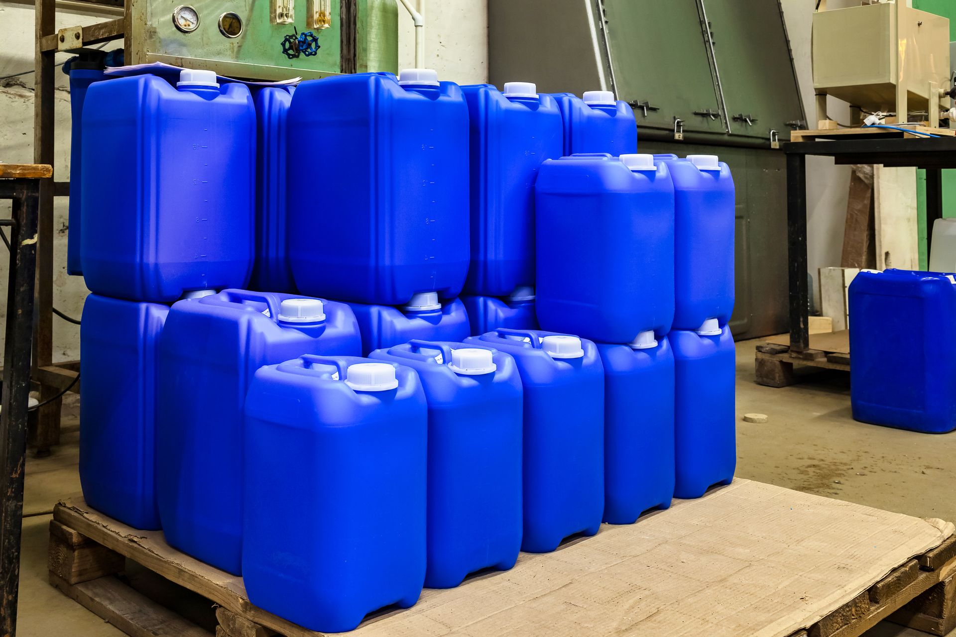 Rows of liquid chemical containers stored on warehouse racking