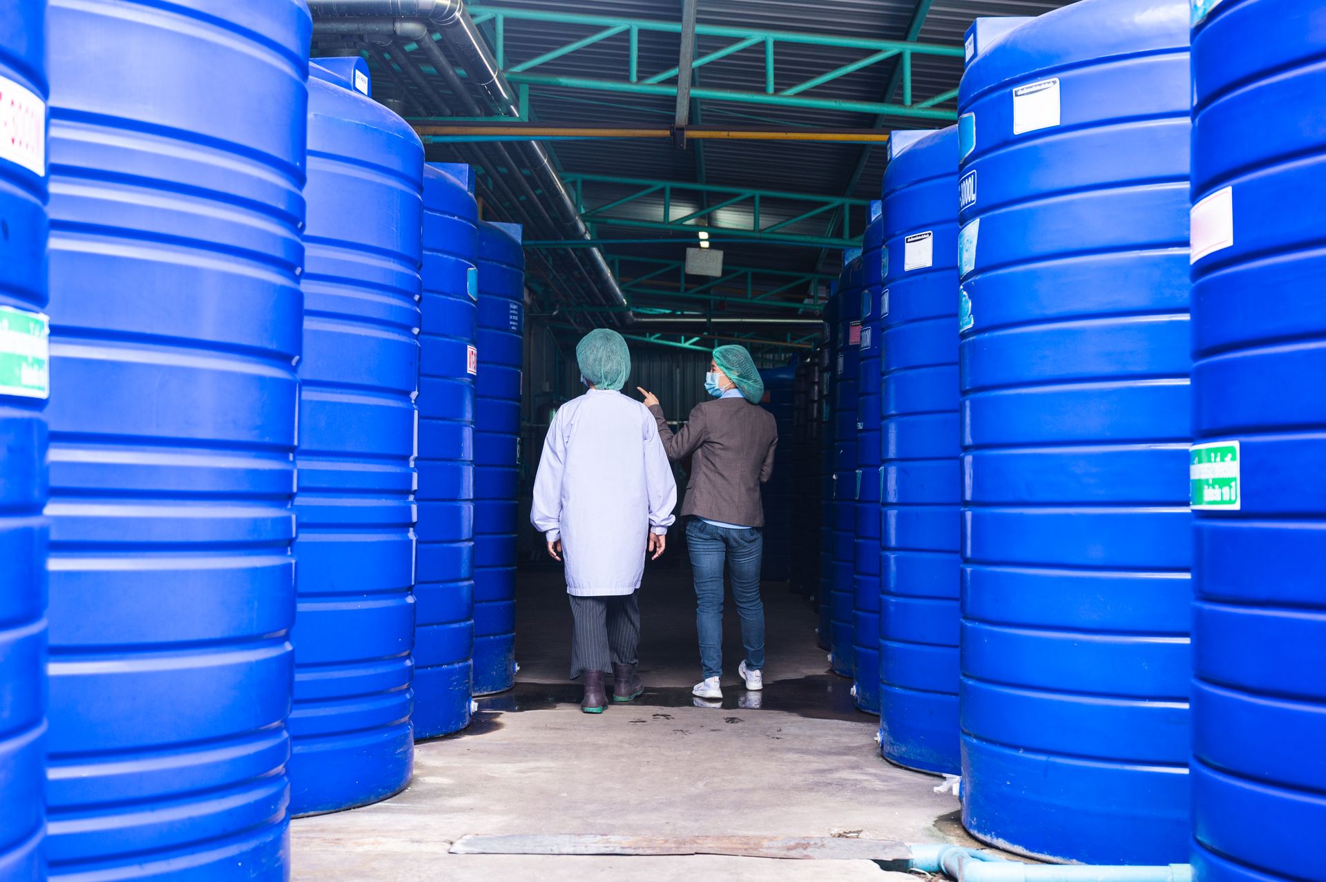 Technicians inspecting a large blue industrial water-treatment tank