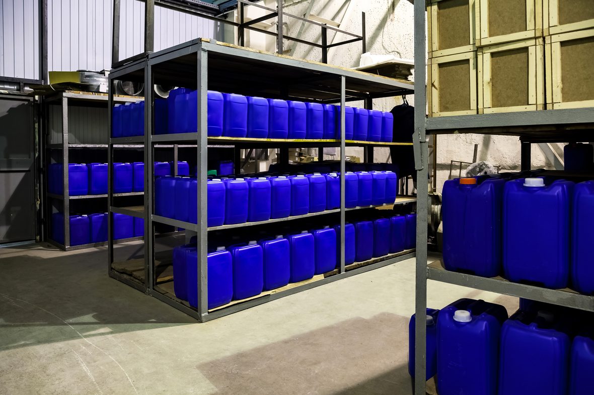 Blue and white chemical IBC containers stored on warehouse racking